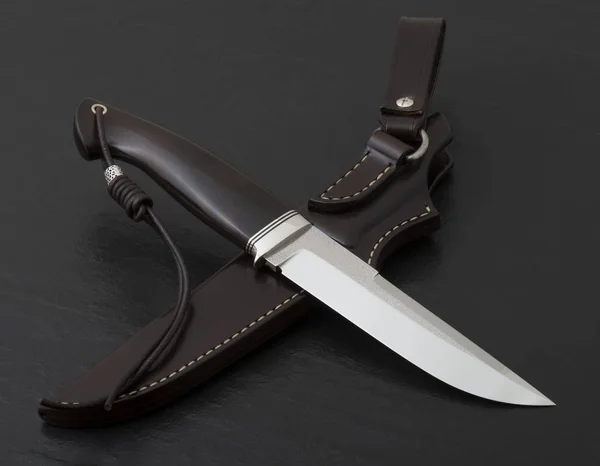 Hunting knife handmade on a black background. Leather Sheath Handmade