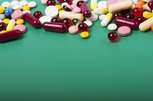 Bunte Pillen Und Kapseln Auf Grünem Hintergrund — Stockfoto