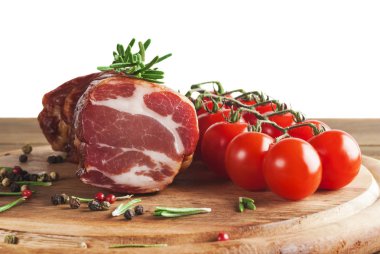 Biberiye ve domates ile ahşap masada lezzetli füme jambon