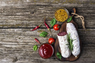 Biberiye, biberiye, kiraz domates ve zeytin ahşap bir arka plan üzerinde İtalyan salam. Afiş. Üstte görüntü