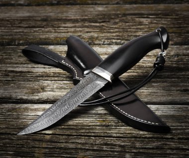 kahverengi ahşap bir arka plan üzerinde el yapımı av bıçağı. Deri Kılıf El Yapımı