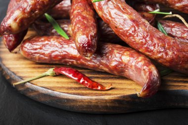 Siyah bir arka plan üzerinde biberiye ve biberiye ile Füme sosis. 