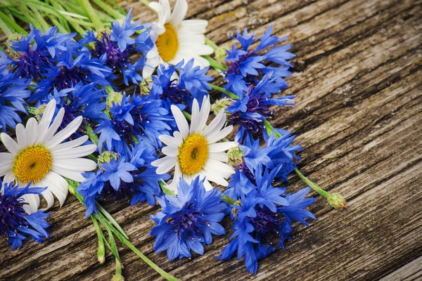 木製の背景にクローズアップ青いトウモロコシの花とヒナギクの花束 — ストック写真