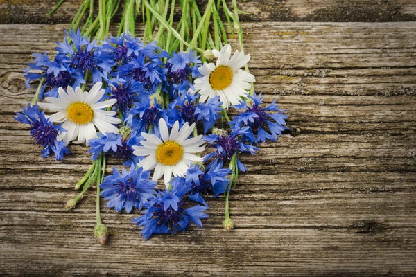 木製の背景にクローズアップ青いトウモロコシの花とヒナギクの花束 — ストック写真