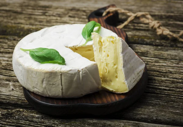 Fransız Peyniri Ahşap Arka Planda Fesleğen Yapraklı Yuvarlak Camembert Peyniri — Stok fotoğraf