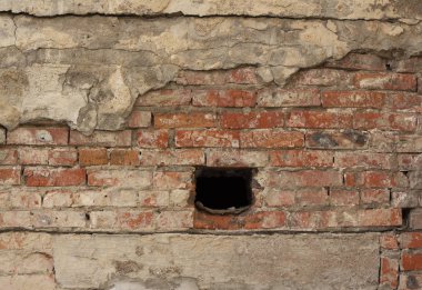 Dışarıda yıllanmış kırmızı tuğla duvar var.