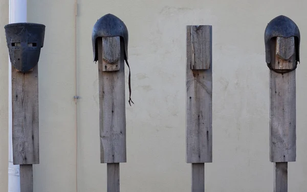 Helmets of medieval warriors on wooden rack