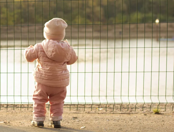 Çocuk demir çitin yanında. 