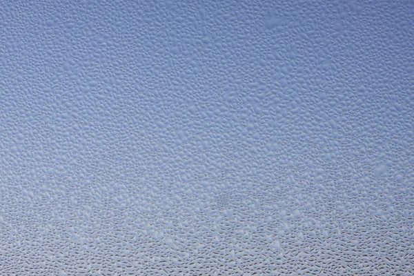 Pencerenin arkasındaki mavi gökyüzü bir sürü damla ile