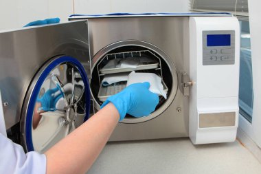 Diş aletlerinin yüksek sıcaklıkta sterilize edilmesi için gardırop. Yüzü olmayan tanınmamış bir fotoğraf. Boşluğu kopyala.