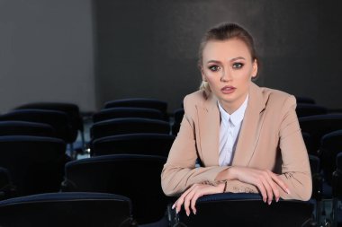 Boş bir konferans odasında takım elbiseli bir kızın portresi. Ekonomik kriz kavramı. Boşluğun kopyası.