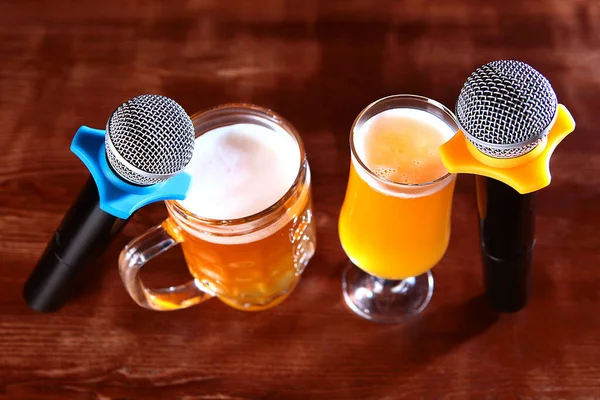 İç taraftaki arka planda iki mikrofon ve bir bardak bira var. Karaoke restoranı konsepti. Boşluğu kopyala. Üst görünüm.