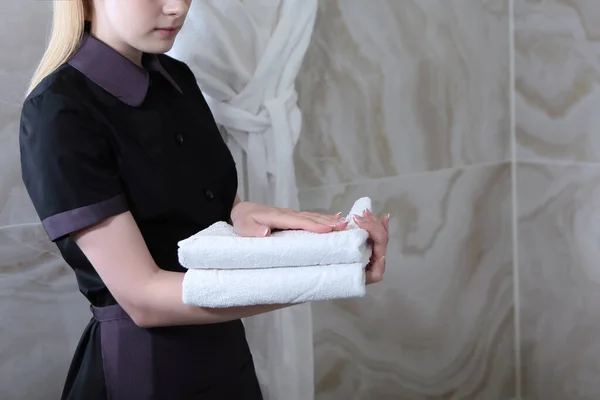 制服を着た少女がバスルームにきれいなタオルを持ってきた ホテルや家庭での清掃サービスのコンセプト スペースのコピー — ストック写真