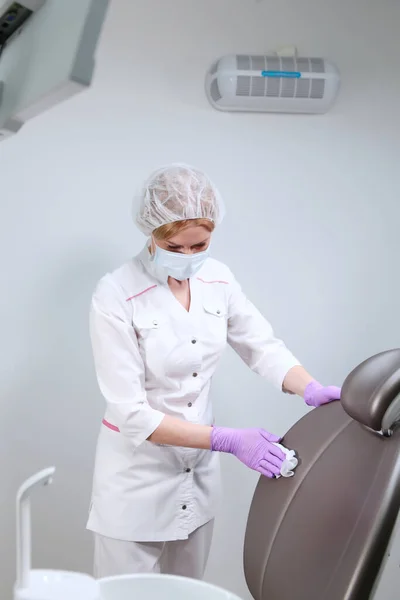 Uma Enfermeira Uniformizada Limpa Uma Cadeira Consultório Dentário Desinfecção Consultório — Fotografia de Stock