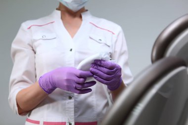 Bir hemşire dişçi muayenehanesinde yüzey silmek için bir bez tutuyor. Klinikte dezenfeksiyon. Yüzü olmayan fotoğraf. Boşluğun kopyası.