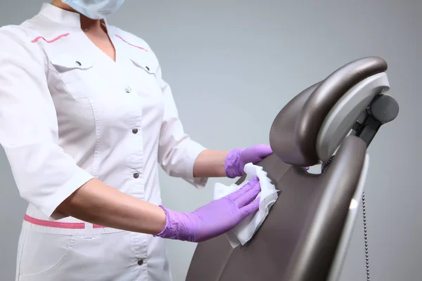 Desinfecção no consultório dentário. Foto sem rosto. A enfermeira limpa as superfícies de trabalho. Cópia do espaço . — Fotografia de Stock