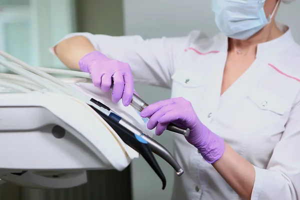 制服を着た看護師と医療マスクが歯科ユニットを拭く 手袋をはめた手歯のオフィスで消毒 コピースペース 灰色の背景 — ストック写真