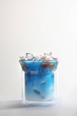 Sütlü mavi kibrit çayı ve bardakta kahve. Alkolsüz. Hafif arkaplan. Uzayı kopyala Dikey fotoğraf.