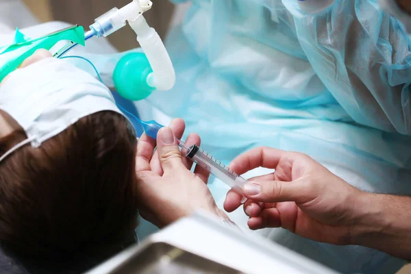 Zbliżenie Ręki Lekarza Strzykawką Podczas Operacji Dziecko Jest Pod Znieczuleniem — Zdjęcie stockowe