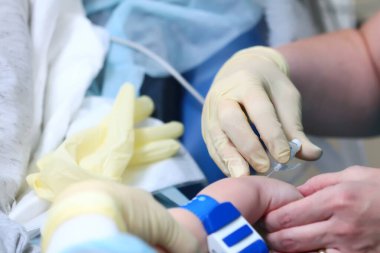 Ameliyattan önce çocuğun genel anestezisine giriş. Asistan iğneyi yapar. Tanımlanamayan fotoğraf. Boşluğu kopyala.