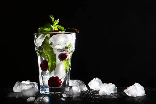 Bebida de cereja refrescante com gelo. Limonada sazonal. Foto sobre um fundo preto. Cópia do espaço . — Fotografia de Stock