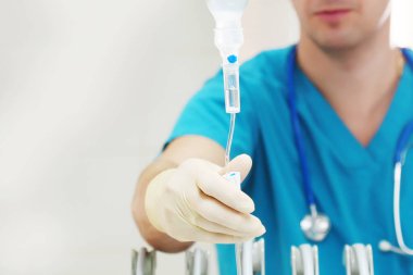 Erkek bir doktor serumu kontrol ediyor. Tanımlanamayan bir fotoğraf. Sadece el. Ameliyathanede fotoğraf var. Boşluğu kopyala.