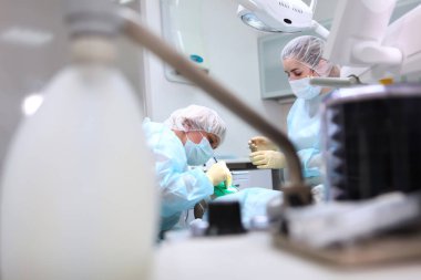 Dişçiler küçük bir çocuğun karnını doyurmak için ameliyat yaparlar. Genel anestezi altında operasyon. Ciğerlerde yapay havalandırma cihazı. Ameliyathanede fotoğraf var. Boşluğu kopyala.