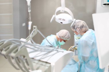 Doktor ve asistan genel anestezi altında çocuğun karnını doyurmak için diş cerrahisi yaparlar. Sağlık kavramı. Boşluğu kopyala.