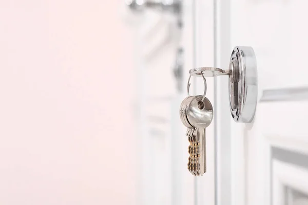 Anahtar deliğinde bir sürü anahtar var. Beyaz kapı. Finansal borç verme veya ipotek kavramı. Yeni bir evde ısınma. Boşluğu kopyala.