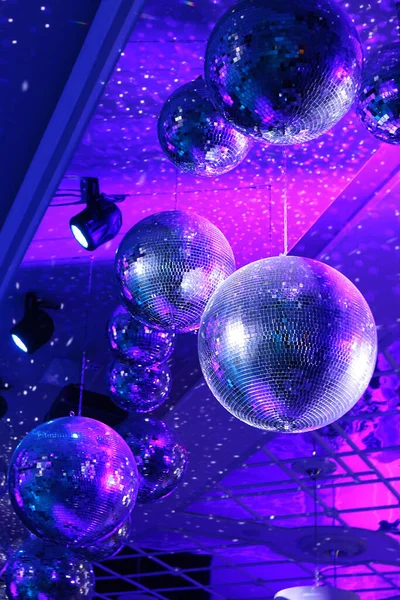 Parlak ışınlı disko topu, mavi arka planlı gece partisi. Gece kulübünde bir sürü gösterişli renkle parti dans salonu kutlaması. Dönen disko ayna topu. Dikey fotoğraf..