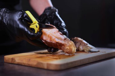 Langoustes yemeği pişiriyorum. Istakozun kabuğunu kes. Tanımlanamayan fotoğraf. Sadece el. Karanlık arka plan. Uzayı kopyala Kapat..