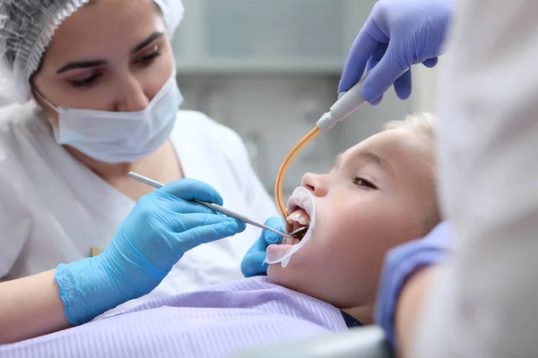 診療所で子供のための専門的な歯科用洗浄。子供の歯医者は子供の歯をきれいにします。光の背景のインテリアで写真。小児科. — ストック写真