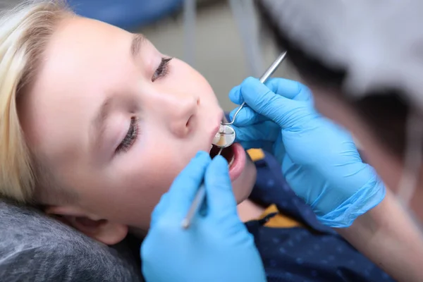 歯医者は小さな男の子の歯を調べる 小児科医との予約 閉めろ 手に歯科用器具 トップ表示 — ストック写真