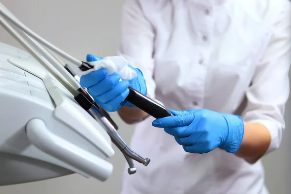 Diş teçhizatı dezenfeksiyonu. Diş asistanı hasta almadan önce aletleri dezenfekte eder. Klinikte hijyen ve hijyen kavramı. Boşluğu kopyala.