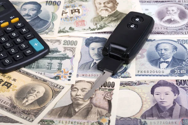 日本货币背景的汽车钥匙 — 图库照片