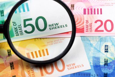 İsrail 'in yeni şekelleri bir büyüteç içinde bir iş arka planı