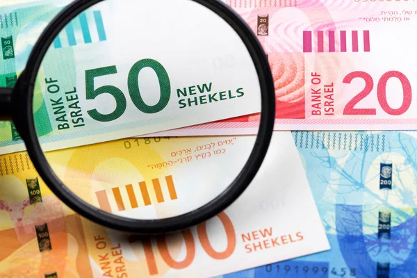 İsrail 'in yeni şekelleri bir büyüteç içinde bir iş arka planı