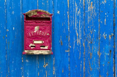 Posta kutusu olan mavi ahşap bir kapı.