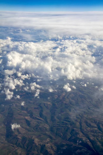在布满云彩的山上从飞机上俯瞰空中 — 图库照片