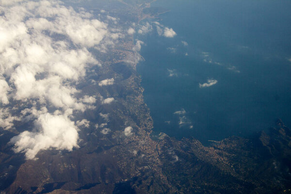 Вид с воздуха с самолета на горы, покрытые облаками
