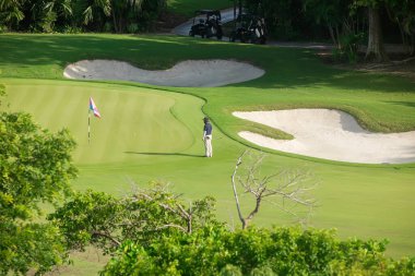 Golf sahasında beyaz bir adam son darbe için hazır, iyi vakit geçiriyor, Playa del Carmen, Meksika 'da golf arabalarıyla başlıyor..