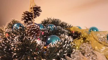 Mavi noel baloları, mavi hediyeler, renkli noel ışıkları ve karlı bir Noel ağacı görünümlü çelenk bulabileceğiniz çeşitli noel süslemelerinin yakın çekimi.