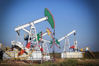 Yazın güneşli bir günde bir tarlada petrol pompalanıyor.