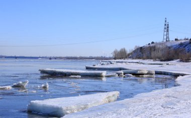 Baharın erken saatlerinde güneşli bir günde nehir üzerindeki buzlar sürükleniyor. 