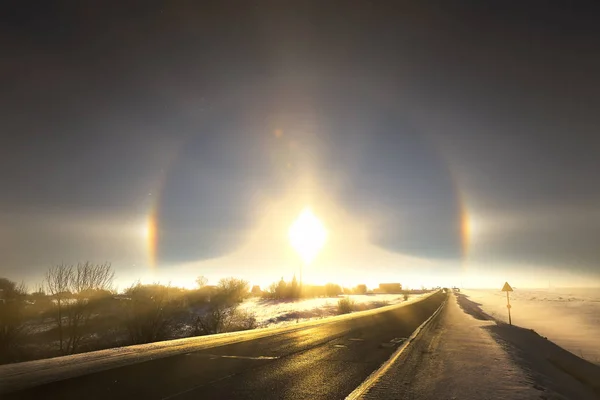 winter landscape beautiful solar halo over the desert road going over the horizon