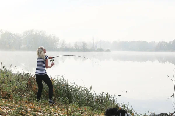 女孩钓鱼雾蒙蒙的秋日早晨在河上 — 图库照片