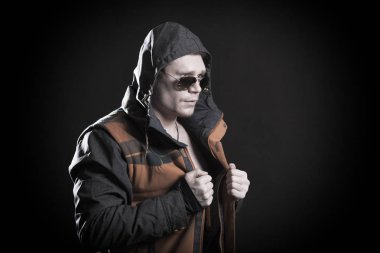 Erkek model gri bir arka plan üzerinde stüdyoda bir kukuleta ile