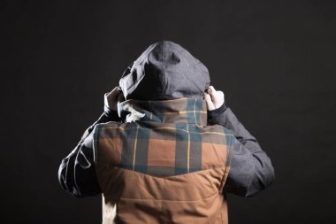 Erkek model gri bir arka plan üzerinde stüdyoda bir kukuleta ile