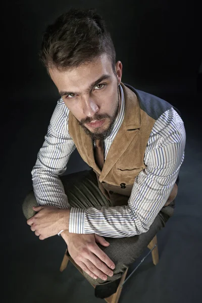 portre portre sakal giyen ile güzel karizmatik genç adamın pantolon, gömlek, yelek ve bir koyu arka plan stüdyo kravat