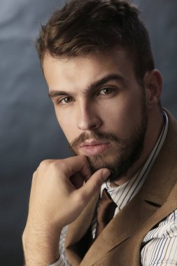 portre portre sakal giyen ile güzel karizmatik genç adamın pantolon, gömlek, yelek ve bir koyu arka plan stüdyo kravat